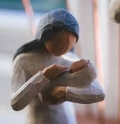 "A statue depicting a woman nursing an infant, symbolizing nurturing and care."