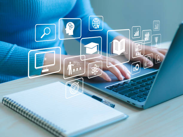 "A person seated with a support person in front of a laptop, receiving guidance to engage in an activity."