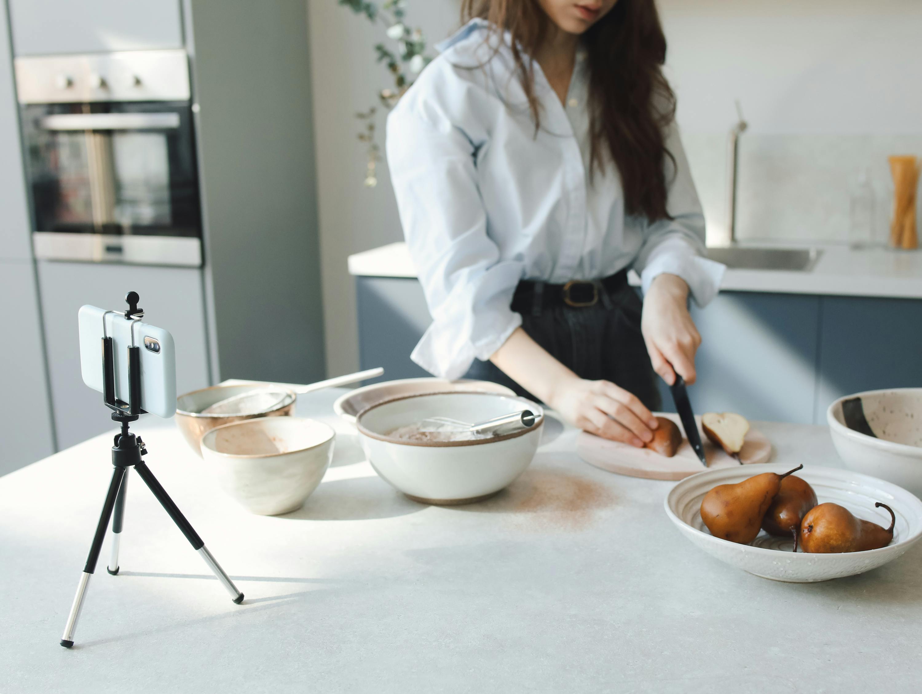 "A woman referencing a recipe displayed on her mobile phone while preparing food."